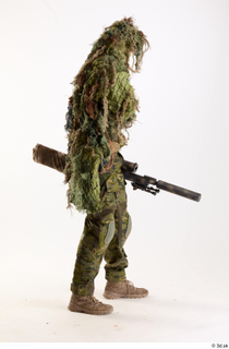 Andrew Elliott in Ghillie Pose with Gun holding gun standing…